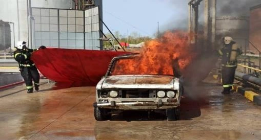 Натурный огневой опыт: испытатели разворачивают противопожарное покрывало CAR FIRE у горящего автомобиля